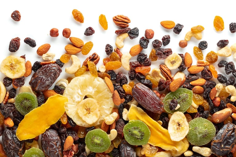 Dried tropical fruits, nuts, and raisins isolated on a white background. Top view.