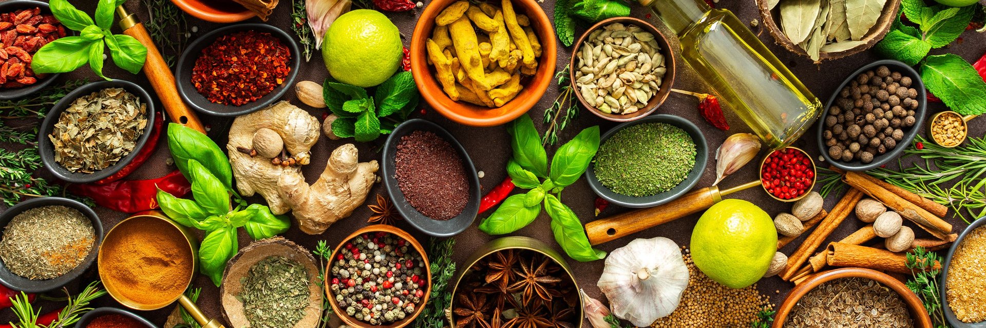 A visually striking arrangement of fresh spices and herbs on a brown surface