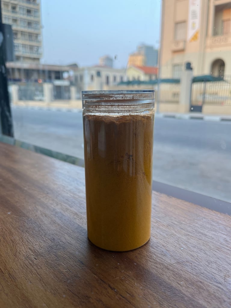A glass of iced cola on a wooden table overlooking an urban cityscape with buildings