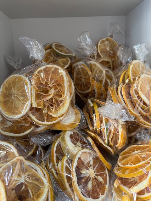 Dried lemon slices packaged in clear plastic bags displayed in a white container
